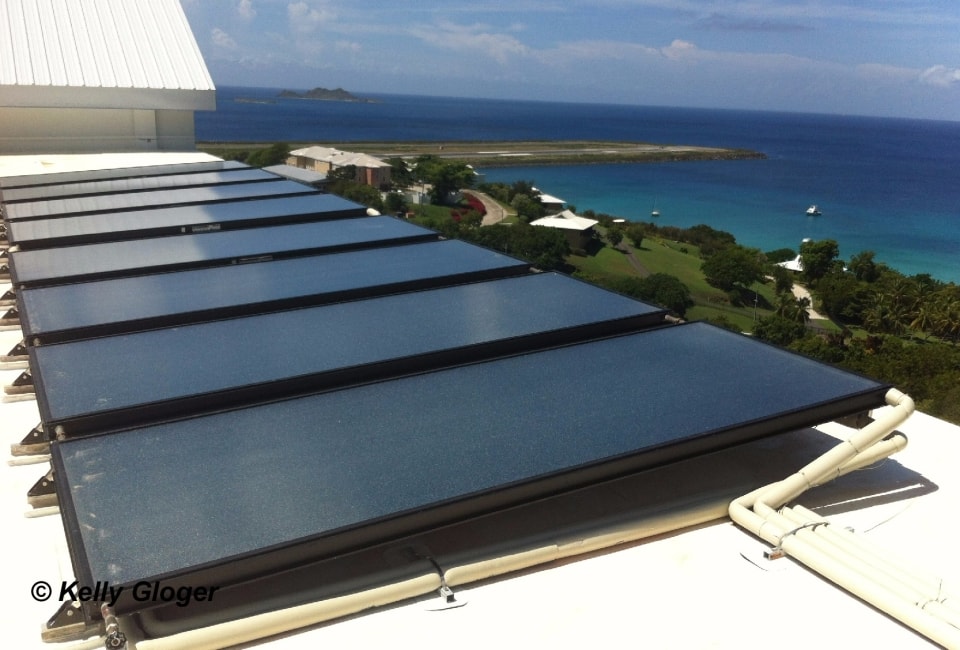 Commercial solar hot water collectors on white roof with Caribbean sea view, USVI