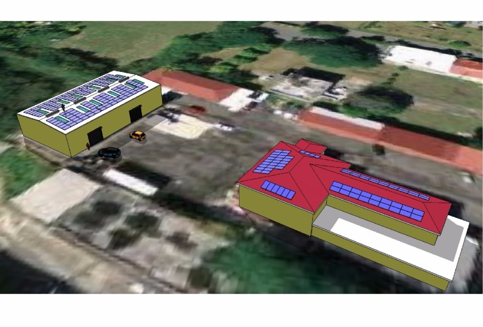 3D aerial rendering showing solar PV arrays on clinic red roof and adjacent yellow warehouse, St. Croix USVI