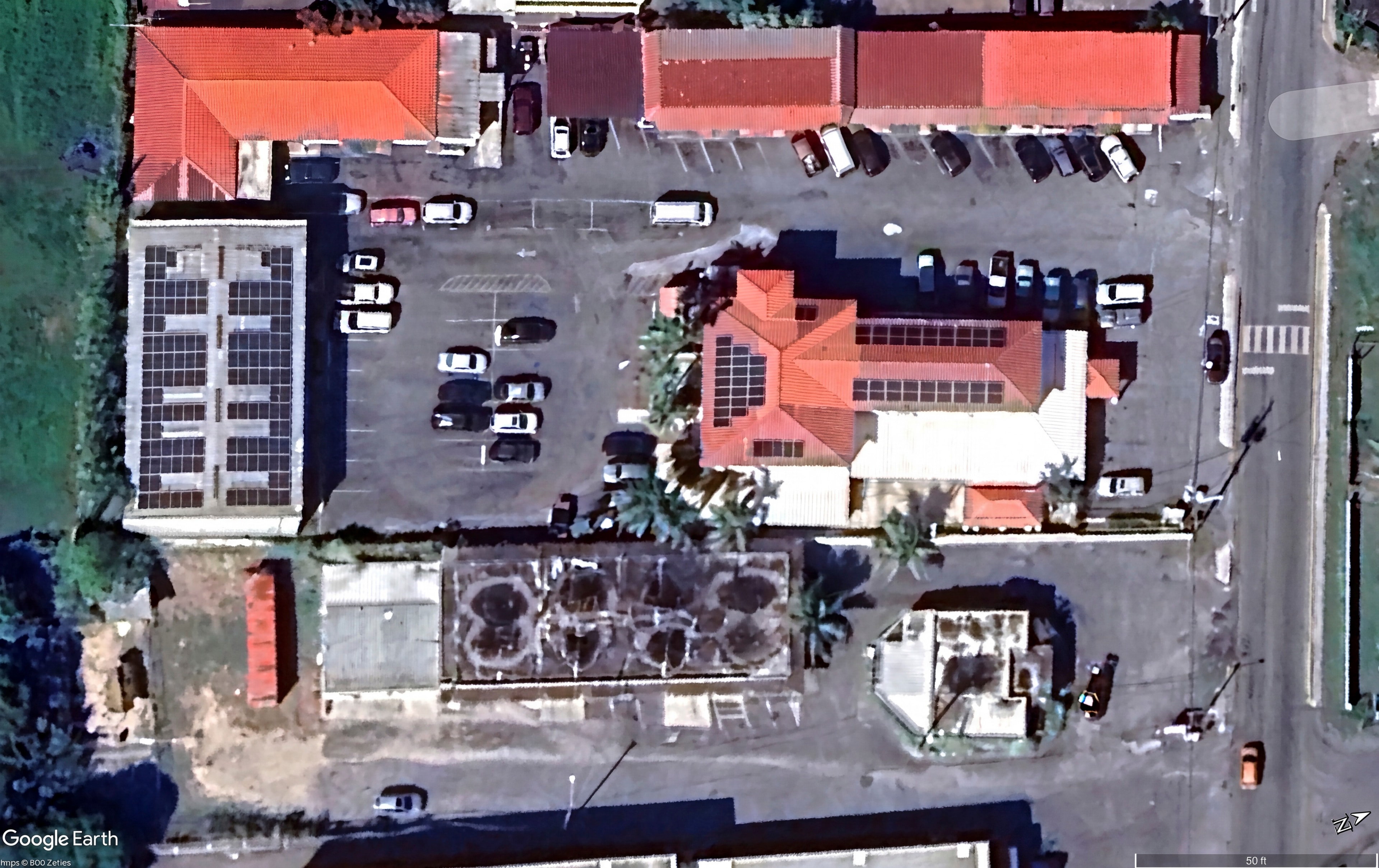 Google Earth satellite image showing completed solar PV installation on clinic and warehouse rooftops, St. Croix USVI