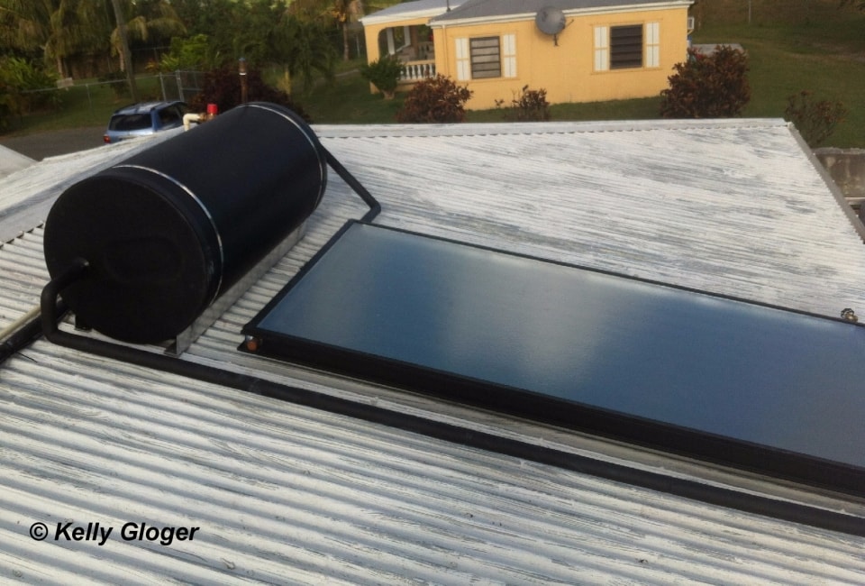 Solar hot water system with black storage tank on corrugated metal roof