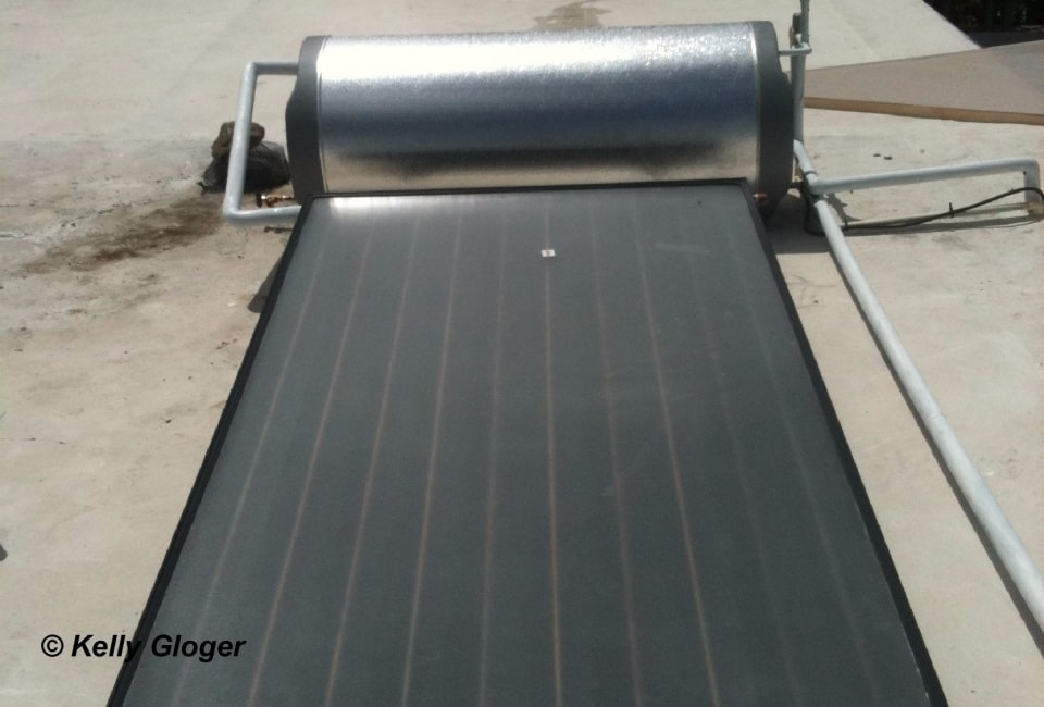 Solar thermal flat-plate collector with integrated storage tank on ground